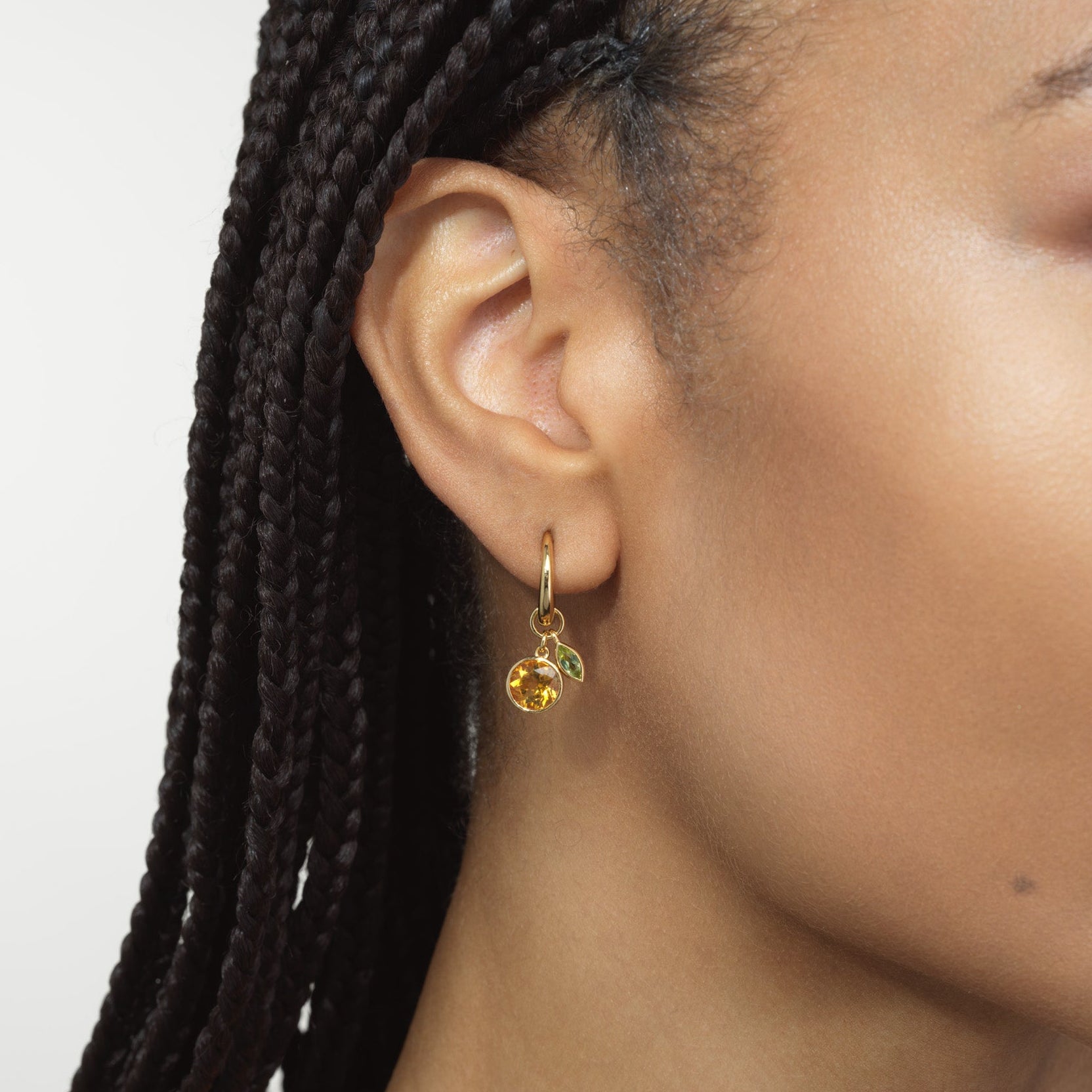 woman wearing mandarin orange charm earrings