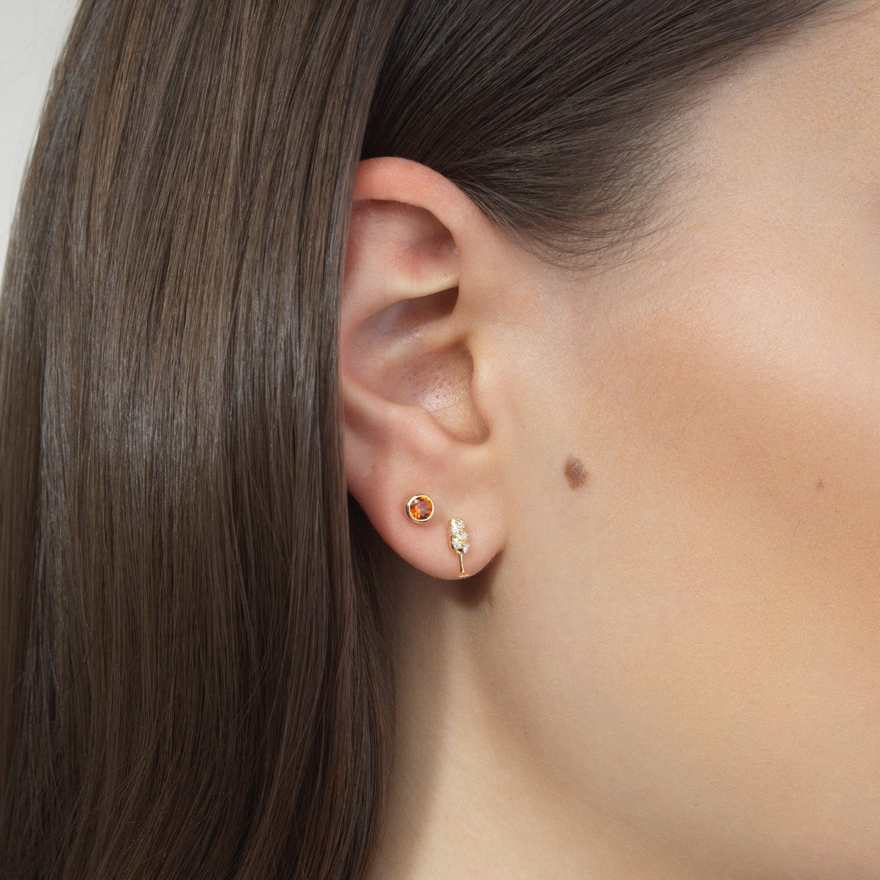 woman wearing orange and champagne stud earrings